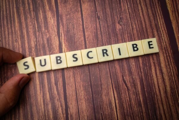Close up shot of wooden blocks spelling the word subscribe on a wooden surface