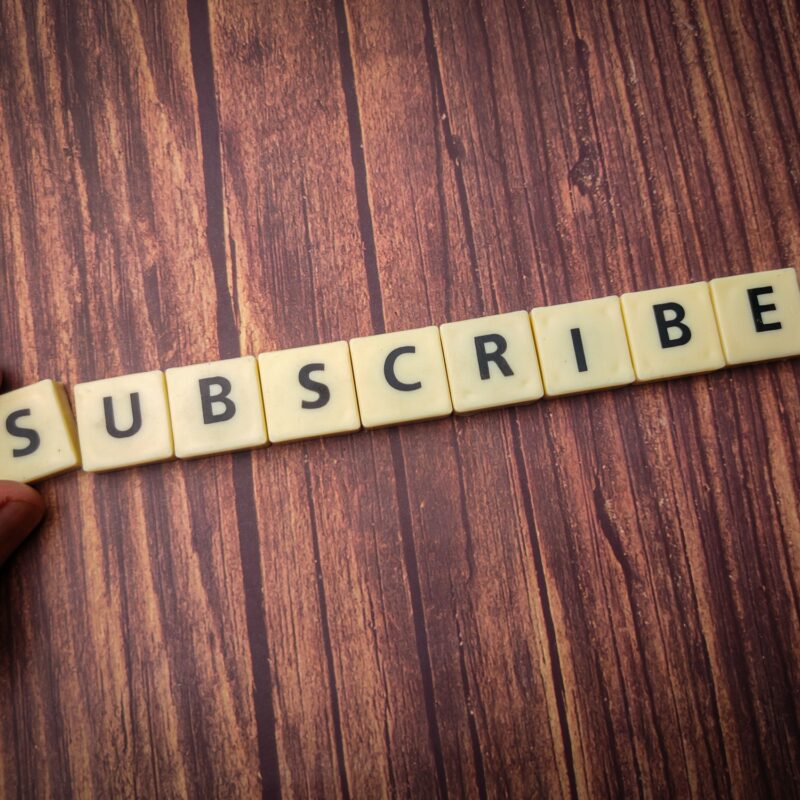 Close up shot of wooden blocks spelling the word subscribe on a wooden surface